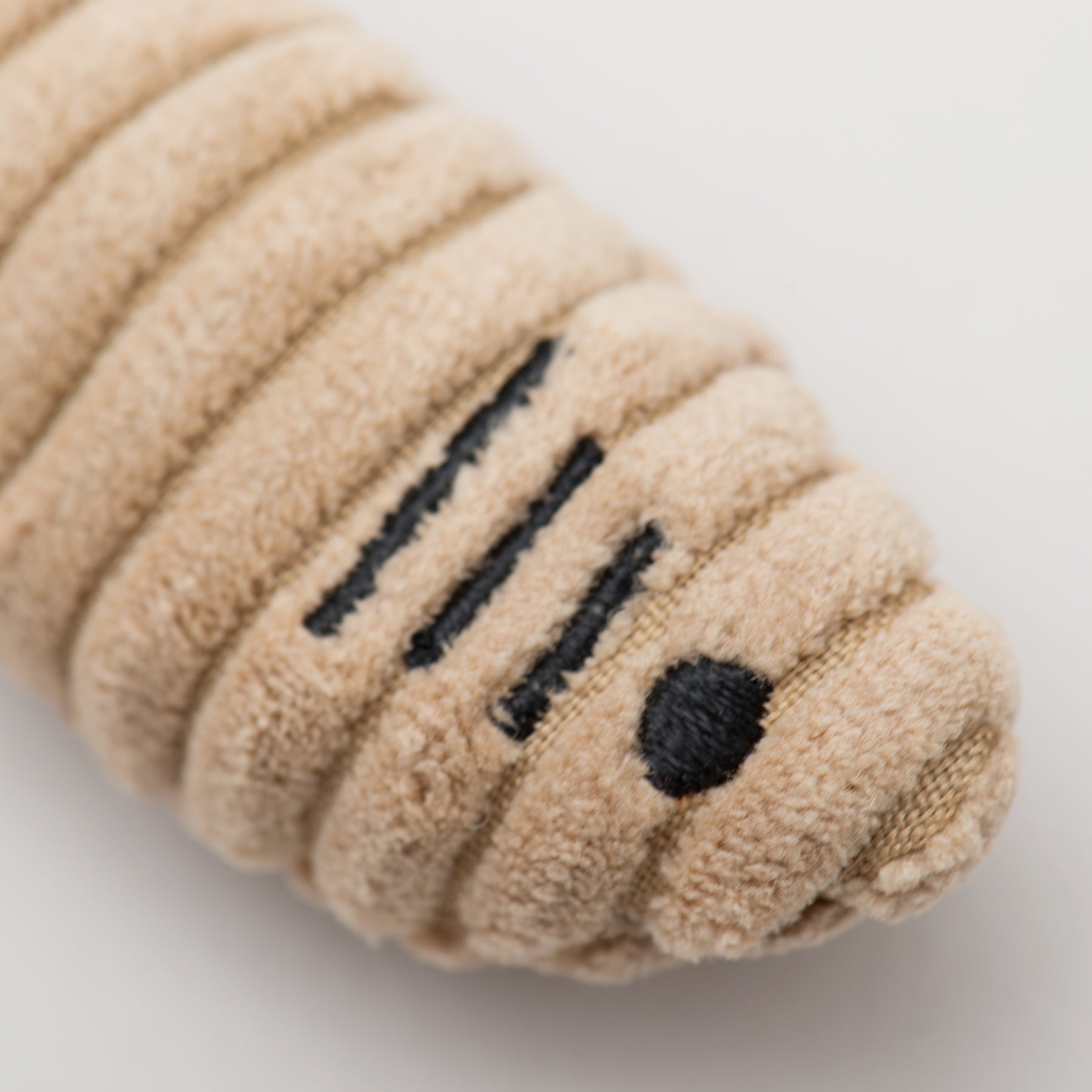 Beige plush cat fish toy with black text on a light gray background.