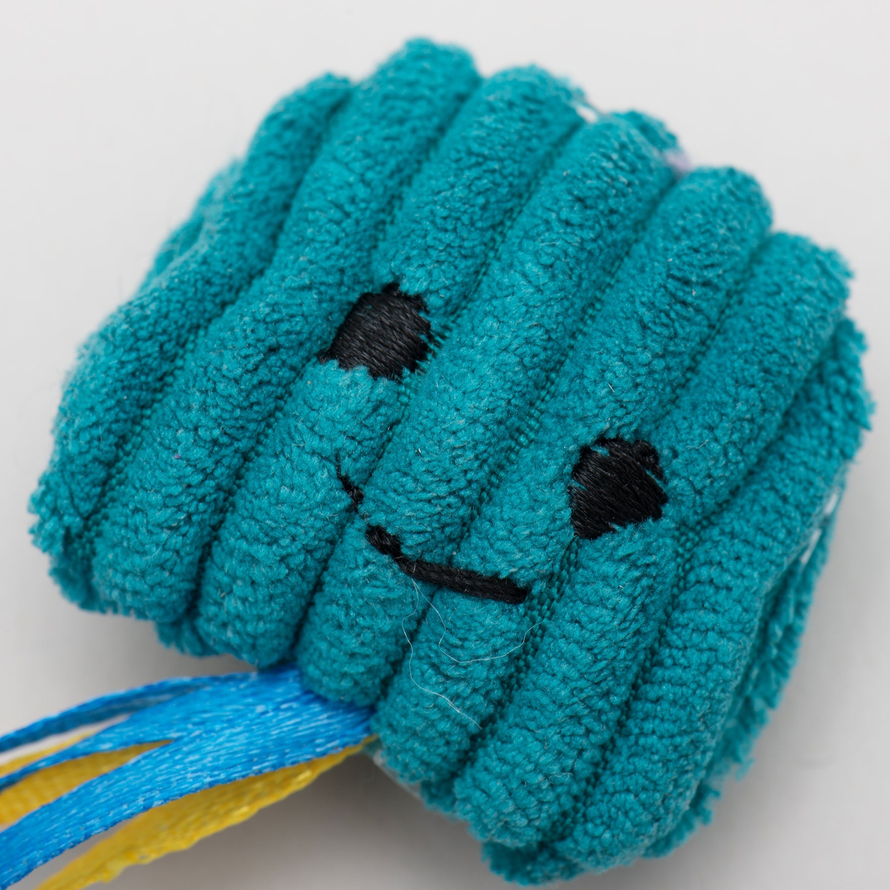 Blue plush cat toy with a happy face on a white background.