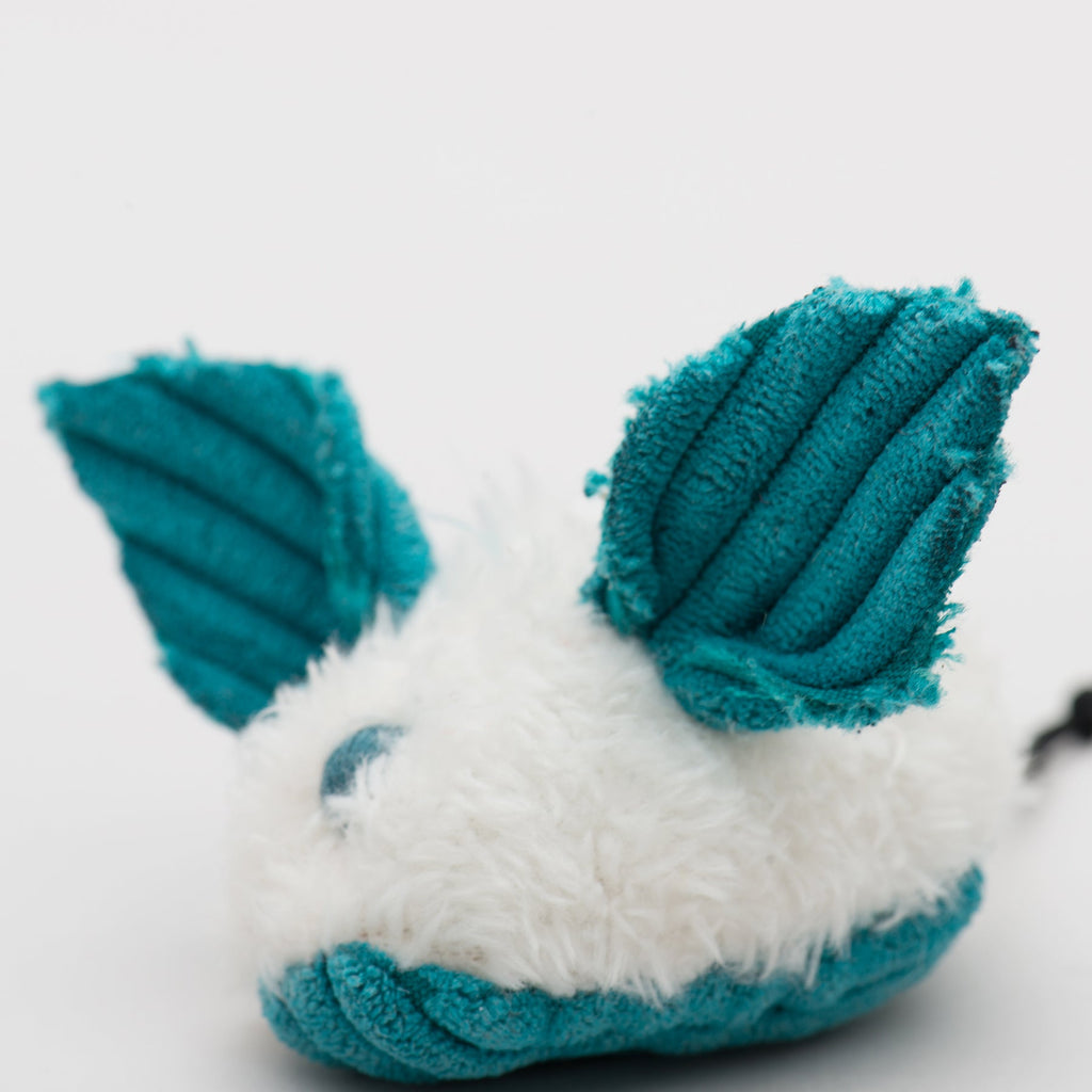 Plush toy with teal ears and white body on a light gray background.