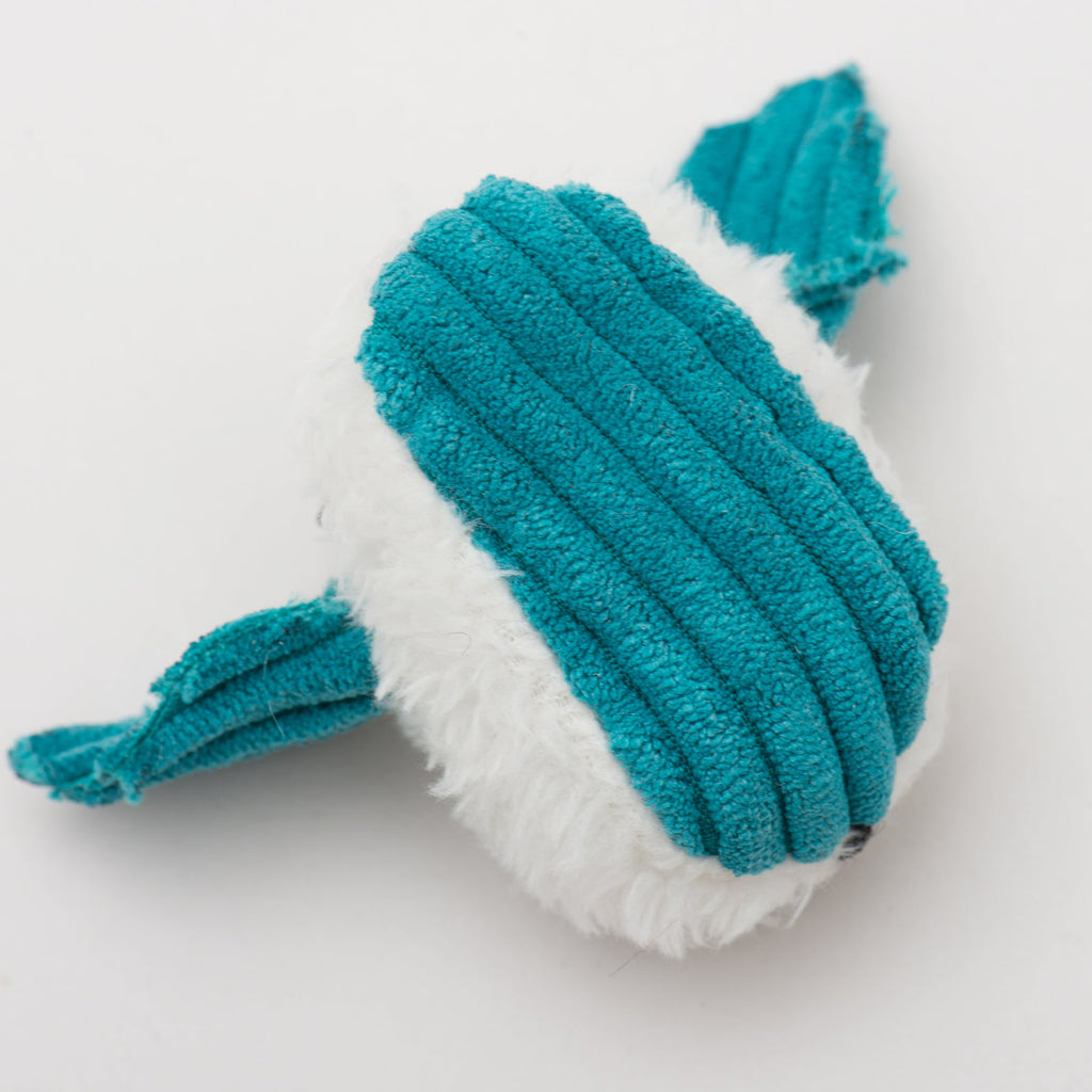 Plush toy resembling a whale with turquoise and white colors on a light gray background.