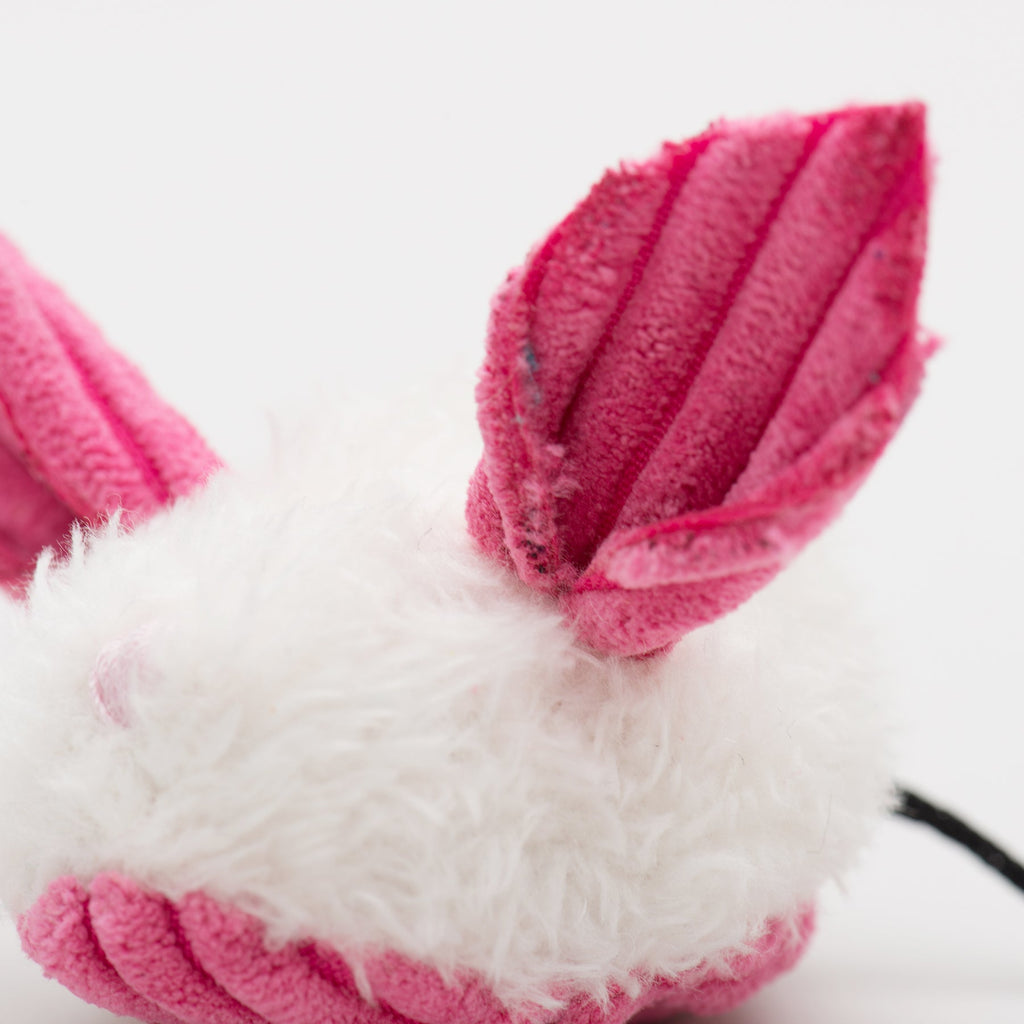 Close-up of pink and white fuzzy slippers on a light background.