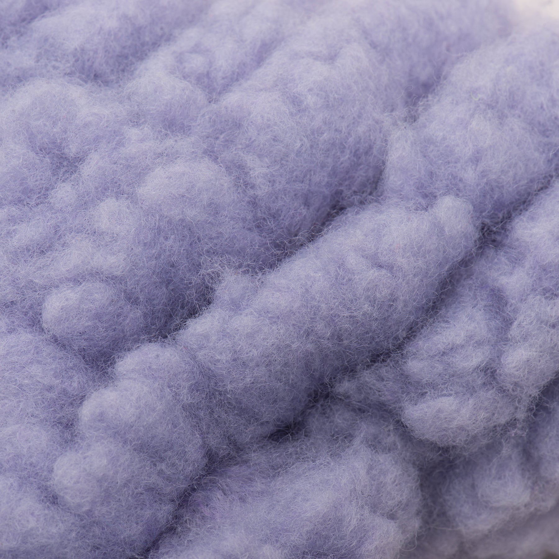 Close-up of fluffy purple dog bone toy.