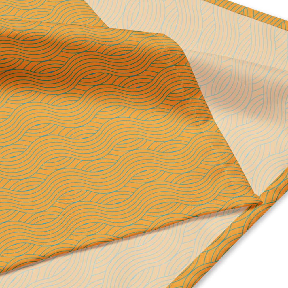Fabric dog bandana with wavy pattern on a beige background.