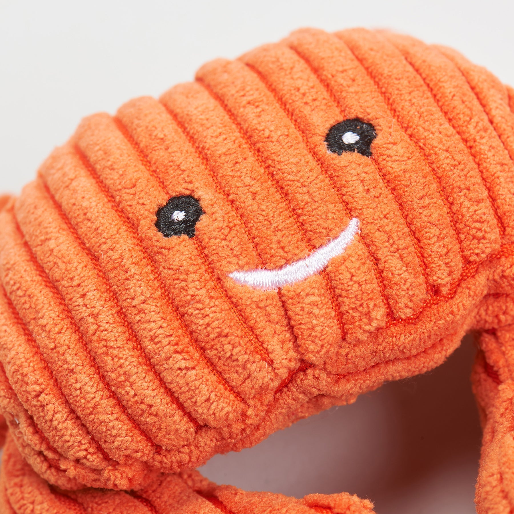 Orange plush crab cat toy with a smiling face on a light gray background.
