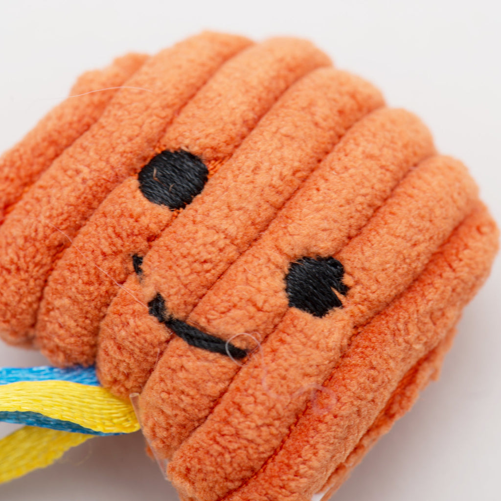 Orange plush cat rope toy with a smiley face on a white background.