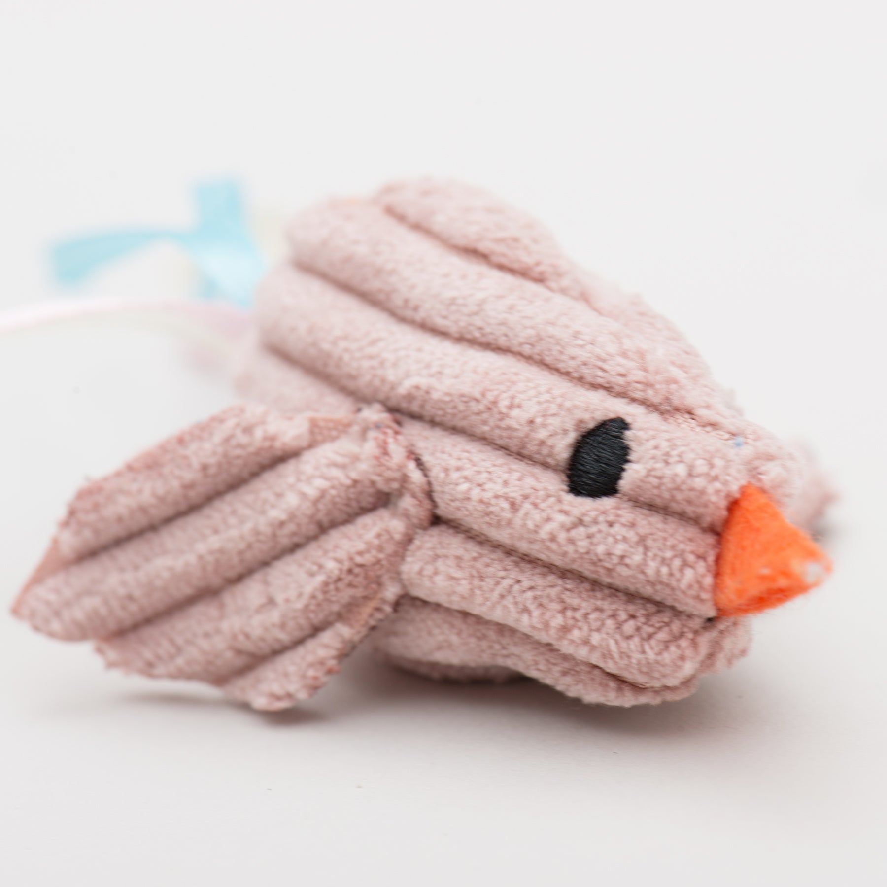 Plush toy shaped like a bird with a pink body, black eye, and orange beak on a white background.