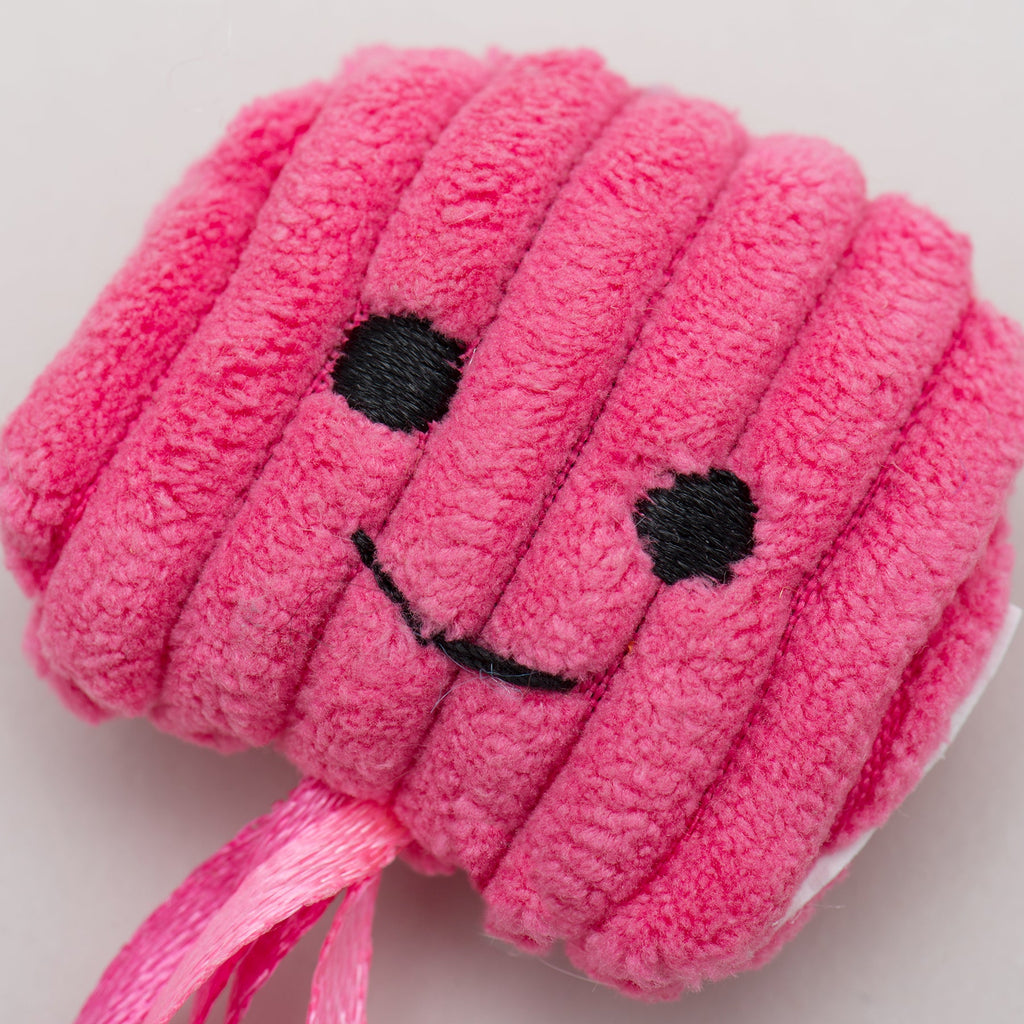 Pink plush cat toy with a smiley face on a light gray background.