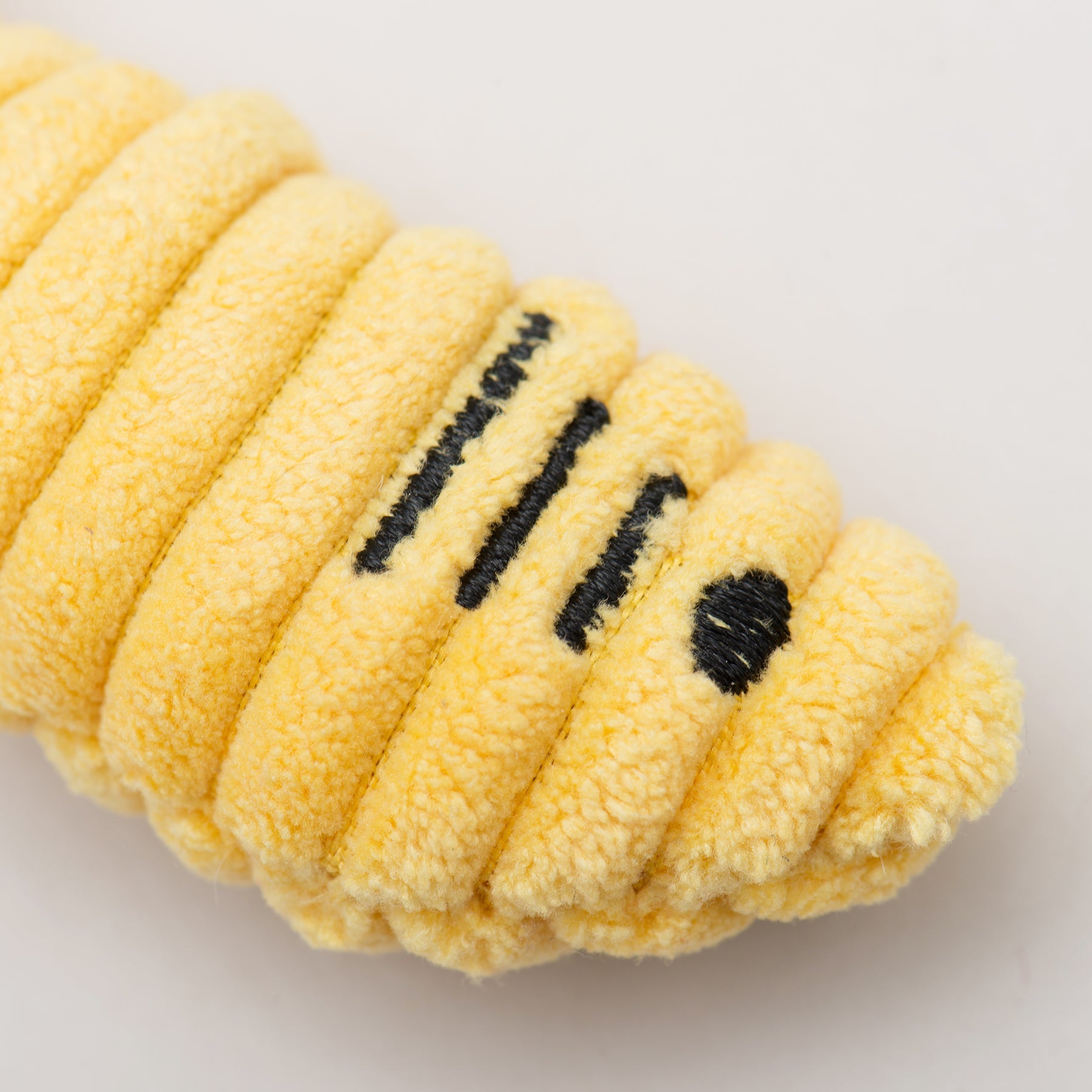 Yellow plush fish cat toy with black text on a light gray background.
